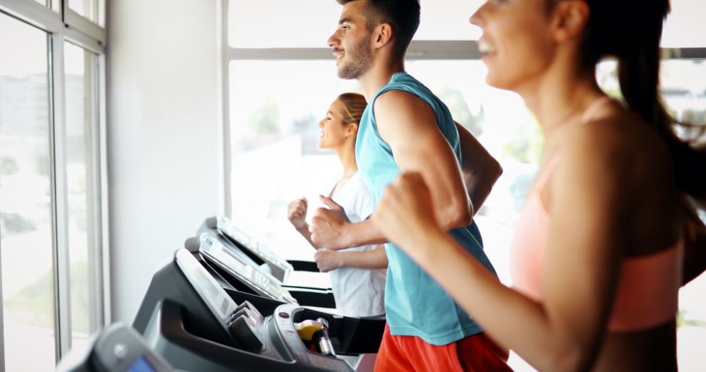 Young gym-goers running on treadmills